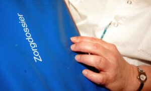 mederwerker maakt aantekening in het zorgdossier
