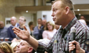 Beeld van iemand die spreekt tijdens een bijeenkomst.