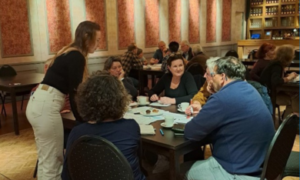 Beeld van een tafel met mensen die werken aan vraagstukken van de workshop